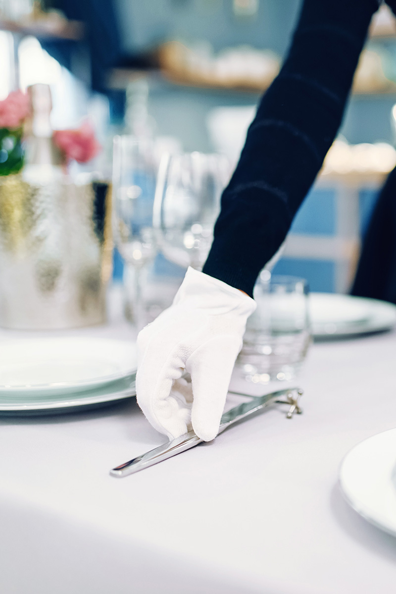 Person, Essen, Präsentation des Essens, Kleidung, Handschuh, Person, Essen, Präsentation des Essens, Kleidung, Handschuh, Tischdecke, Teller, Besteck, Handschuh, Tischdekoration, Tischdecke, Besteck, Gabel, Glas, Handschuh